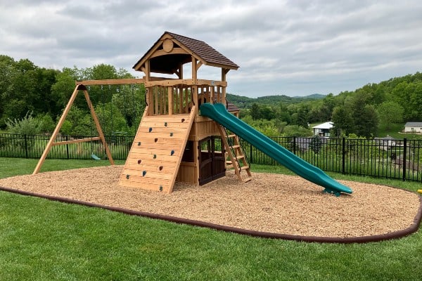 playset with safety surface installed including curbing